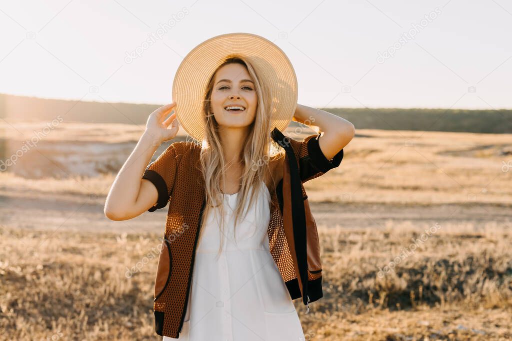 portrait of beautiful blonde woman on nature during sunset