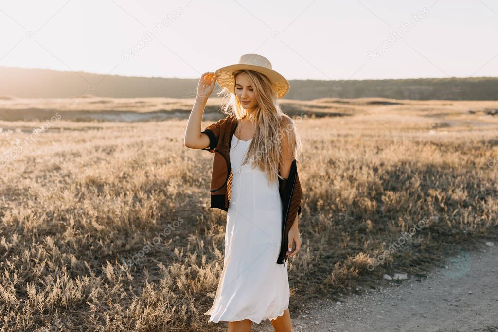 portrait of beautiful blonde woman on nature during sunset