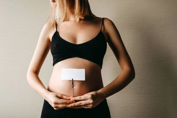 Zwangere Vrouw Met Een Leeg Wit Stuk Papier Voorkant Van — Stockfoto