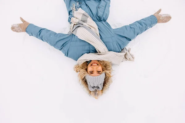 Веселая Молодая Женщина Лежа Снегу Делая Снежного Ангела Улыбаясь — стоковое фото