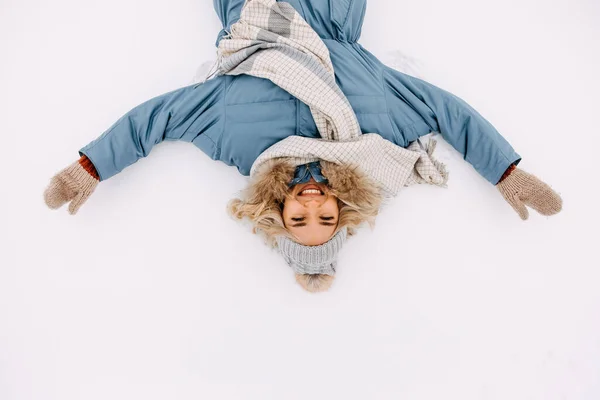 Allegro Giovane Donna Bionda Sdraiata Sulla Neve Facendo Angelo Neve — Foto Stock