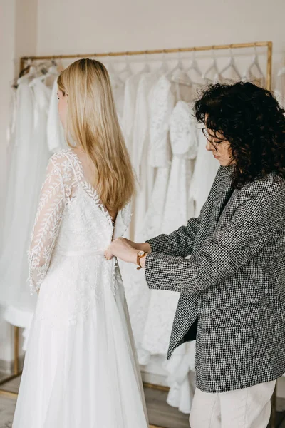 Sprzedawca Pomaga Klientowi Założyć Suknię Ślubną — Zdjęcie stockowe