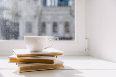 Boş bir fincan kahve ya da pencerenin kenarındaki kitap yığınının üzerinde çay..