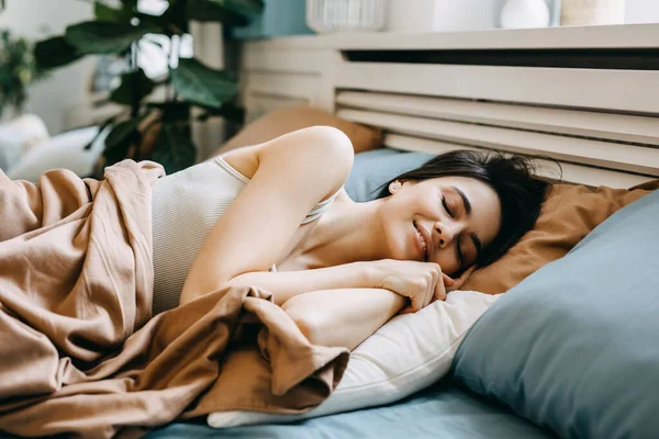 目を閉じて 目を閉じて 午前中にベッドに横たわっ若い女性 ロイヤリティフリーのストック画像