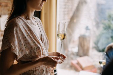 Bir bardak şampanyayla birlikte elbiseli genç bir kadın..