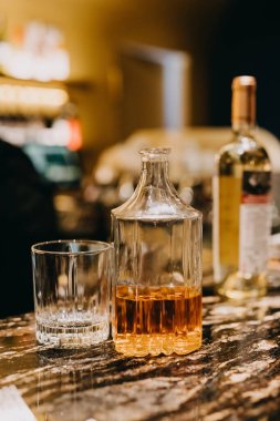 Bir şişe viski ve tezgahta bir bardak..