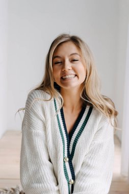 Genç sarışın bir kadının duygusal portresi gülümsüyor, kameraya bakıyor..