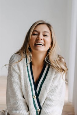 Genç sarışın bir kadının duygusal portresi gülüyor, kameraya bakıyor..