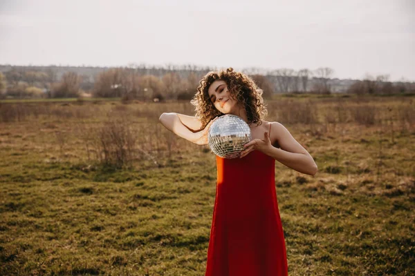 Mladá Žena Kudrnatými Vlasy Červených Šatech Držící Diskotéku Poli — Stock fotografie