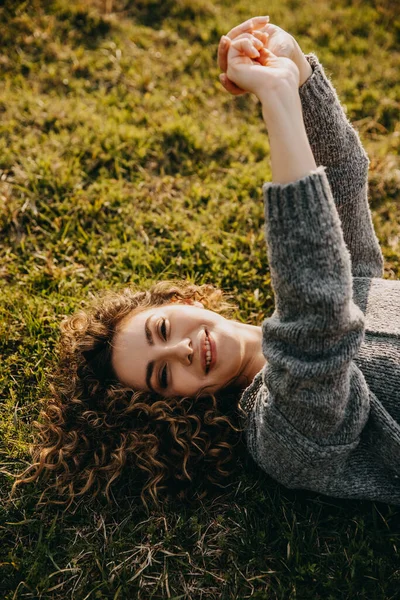 Joven Mujer Feliz Con Pelo Rizado Acostado Hierba Con Suéter — Foto de Stock