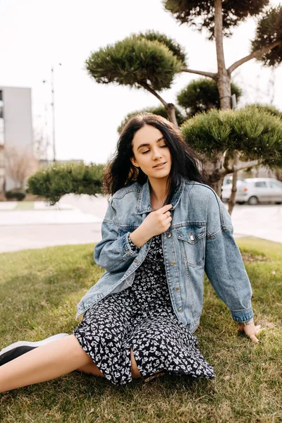 Young Brunette Woman Wearing Denim Jacket Dress Sitting Grass Park — Stock Photo, Image