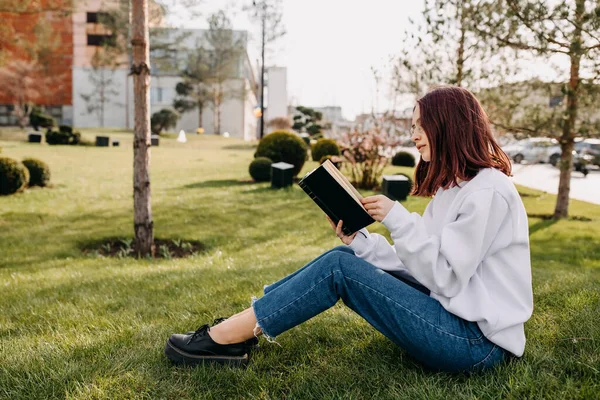 Κορίτσι Φοιτητής Κάθεται Στο Πράσινο Γρασίδι Εξωτερικούς Χώρους Διαβάζοντας Ένα — Φωτογραφία Αρχείου
