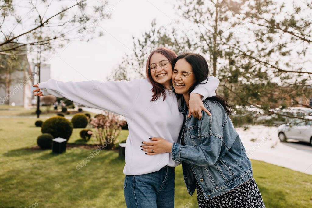 Two best friends spending fun time together outdoors, hugging and laughing. Sisters concept.