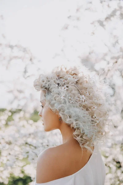 春の日に庭で 彼女の髪に桜の花と 若いブロンドの女性の笑顔の閉鎖 — ストック写真