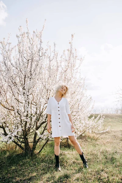 Mladá Blondýnka Kudrnatými Vlasy Sobě Bílé Šaty Pózování Třešeň Květovém — Stock fotografie