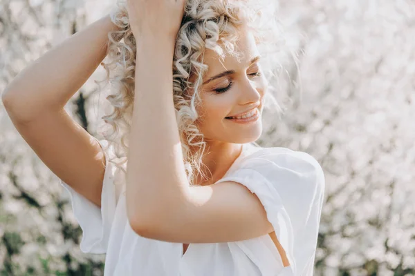 Молода Блондинка Кучерявим Волоссям Посміхаючись Фоні Вишневих Квітів Саду — стокове фото
