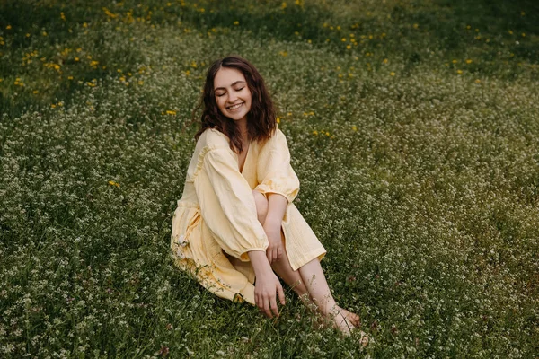 Mladá Žena Žlutých Mušelínových Šatech Sedící Poli Zelenou Trávou Divokými — Stock fotografie