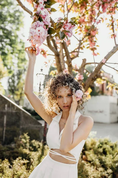 Young Woman Curly Hair Posing Outdoors Next Tree Bloom Pink — Foto de Stock
