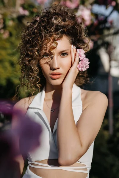 Jovem Com Cabelo Encaracolado Posando Livre Com Flores Rosa — Fotografia de Stock