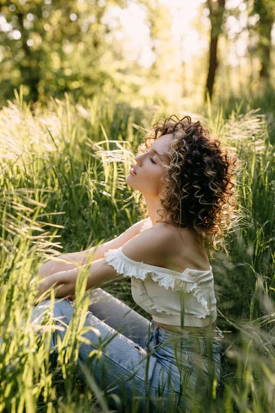 Jovem Com Cabelo Encaracolado Curto Sentado Grama Verde Parque Relaxante — Fotografia de Stock