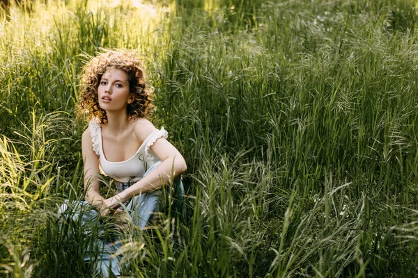 Young Woman Short Curly Hair Sitting Field Tall Green Grass — Foto de Stock
