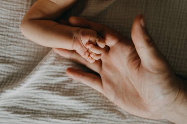 Babanın küçük bebek elini tuttuğu yakın plan..