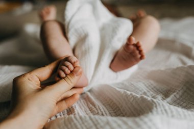 Anne kucağında küçük bebek ayağı.