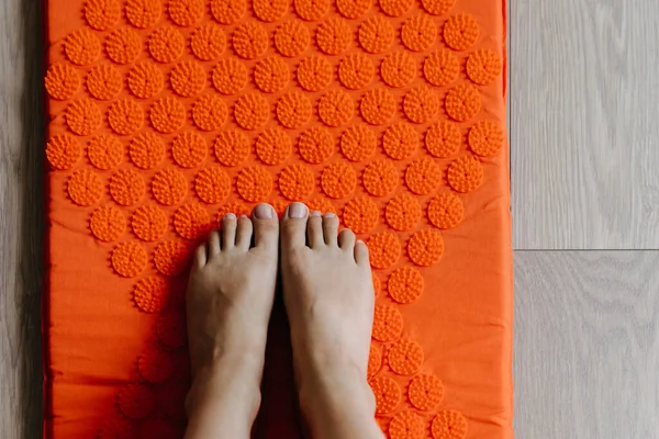 Vrouwelijke Voeten Een Orthopedische Oranje Mat Met Spikes Massage Ontspanning — Stockfoto
