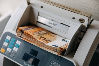 50 avroluk banknotları bir sayım makinesine koy.