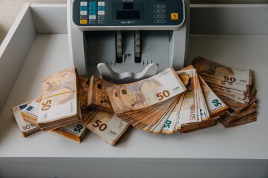 Bir sayım makinesinin yanında bir sürü 50 avroluk banknot..