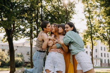 Group of young women in a park, having good time, hugging and smiling.