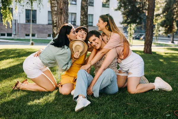 Група Чотирьох Жінок Сидять Парку Зеленій Траві Обіймаються Сміються — стокове фото