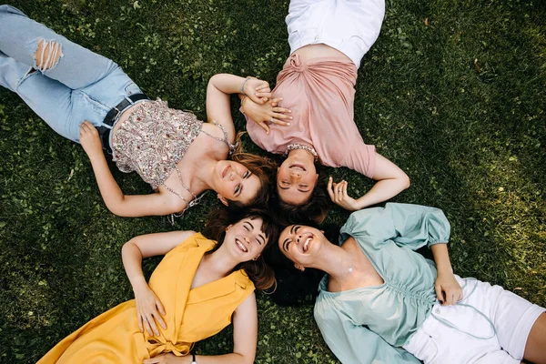 Group Four Young Women Lying Green Grass Outdoors Park Laughing — Stockfoto