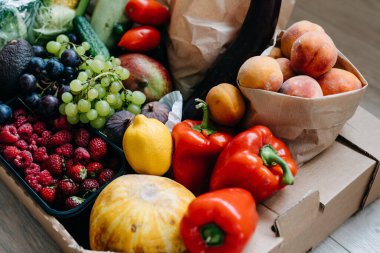 Bir kutu dolusu taze organik sebze, meyve ve çilek. Yiyecek teslimatı kavramı.