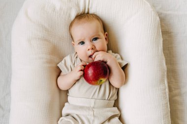 Elma tutan bir bebek. Gıda çeşitlendirme kavramı.