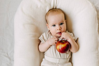 Elma tutan bir bebek. Gıda çeşitlendirme kavramı.