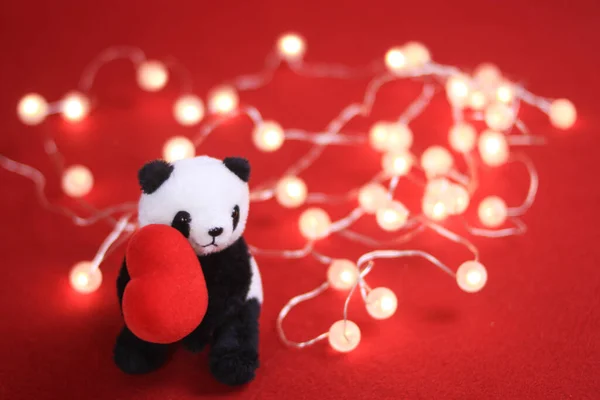Panda Plush Doll with Christmas ornaments on red background