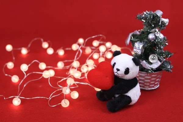 Panda Plush Doll with Christmas ornaments on red background