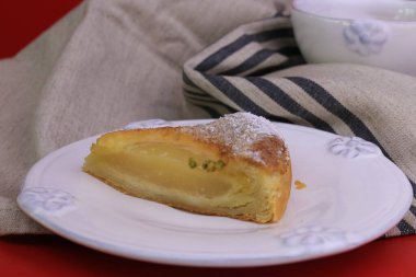 Üzerinde ezilmiş çam fıstığı ve siyah arka planda ezilmiş fındık olan Armut turtasını kapat.