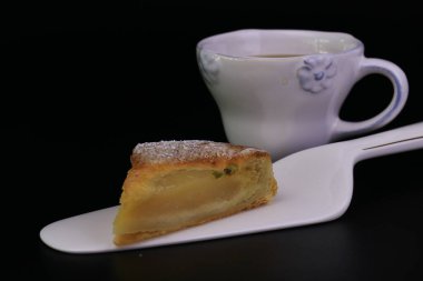 Üzerinde ezilmiş çam fıstığı ve siyah arka planda ezilmiş fındık olan Armut turtasını kapat.