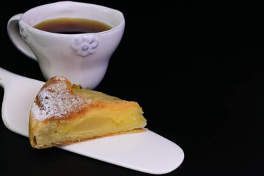 Üzerinde ezilmiş çam fıstığı ve siyah arka planda ezilmiş fındık olan Armut turtasını kapat.