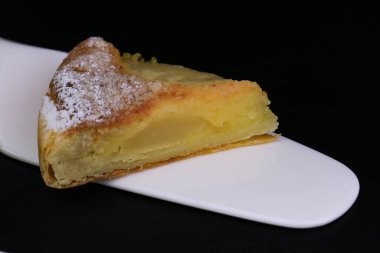 Üzerinde ezilmiş çam fıstığı ve siyah arka planda ezilmiş fındık olan Armut turtasını kapat.