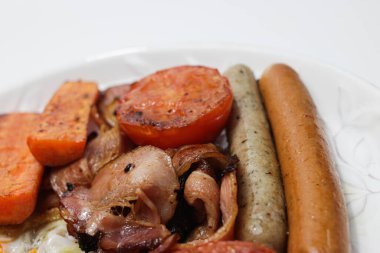 Kıta kahvaltısı, kızarmış yumurta, sosis, havuç, domates ve pastırma.