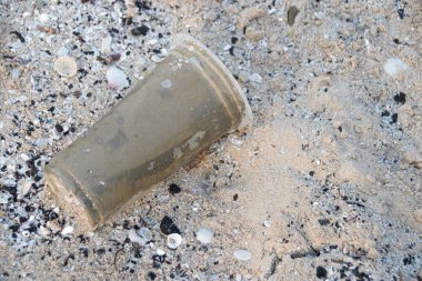 Plajdaki kirlilik, plastik torbalar, şişeler, çatlak kumdaki maskeler, Çevresel Kriz