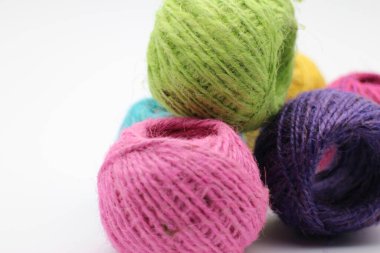  Beyaz arkaplanda jüt sicimin renkli makaralarını gösterir