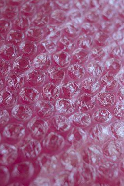 Pembe arkaplanda şeffaf baloncuk paketini kapat