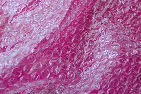 Pembe arkaplanda şeffaf baloncuk paketini kapat