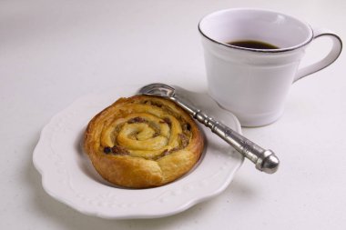 Çalışma masasında sıcak kahve ve tarçınlı çörek var.