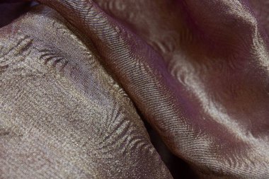 Işıldayan, renk değiştiren etki, genellikle farklı renklerde dokuma iplikleriyle oluşturulan yanardöner kumaşın bir karakteristiğidir. Kumaşın katıksız, hafif kalitesine bakılırsa bir tür ipek metalik yakut şifon olabilir. 