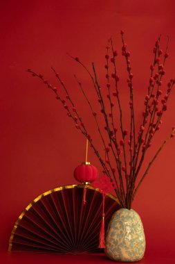 Zengin, kırmızı bir zemin üzerine kurulmuş zarif bir şenlik hayatı. Altın kaplamalı geleneksel bir kırmızı pervane, küçük bir asılı fener ve uğurlu bir Çin düğümü..